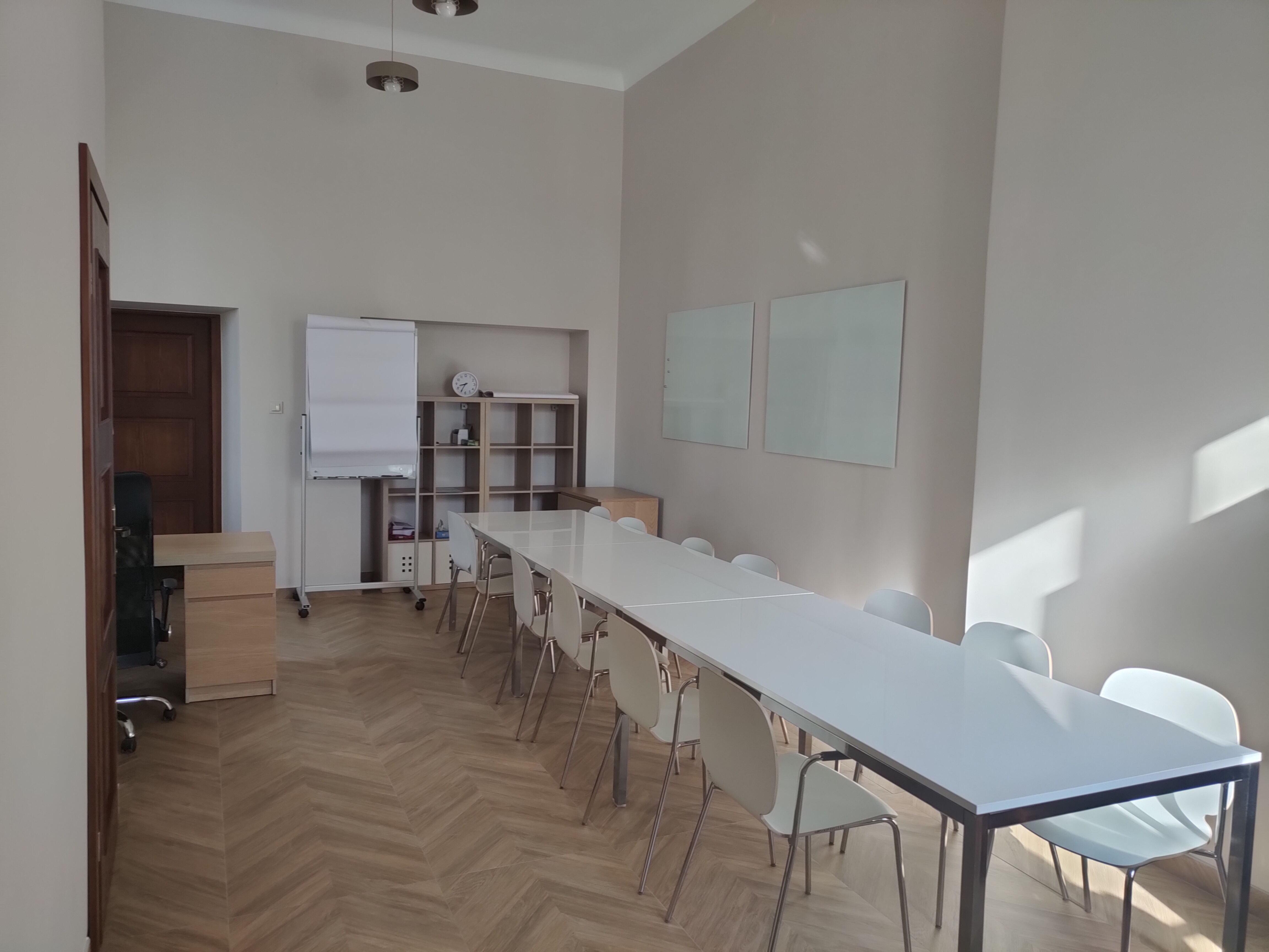 Sala z białymi stołami i krzesłami